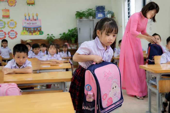 Bạn nhỏ xách cặp vào chỗ ngồi